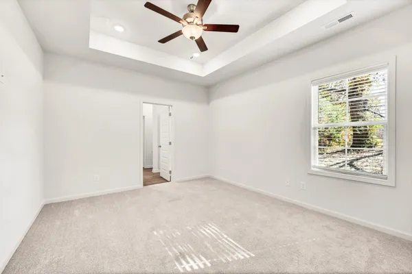 an empty room with windows and fan