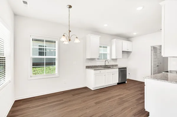a open kitchen with white cabinets and stainless steel appliances