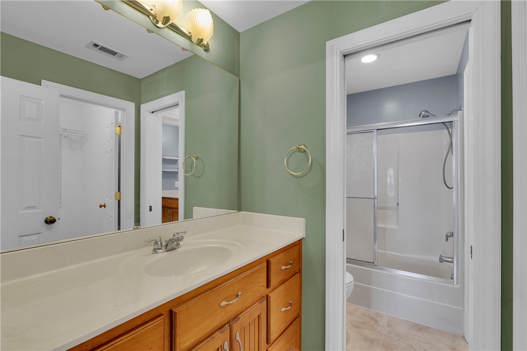 406 Hopewell Ridge Anderson, SC 29621 - Photo 28 of 46 This bathroom features a functional vanity with ample storage, a mirrored wall, and a shower-tub combination.