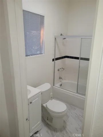 a white toilet sitting next to a bath tub