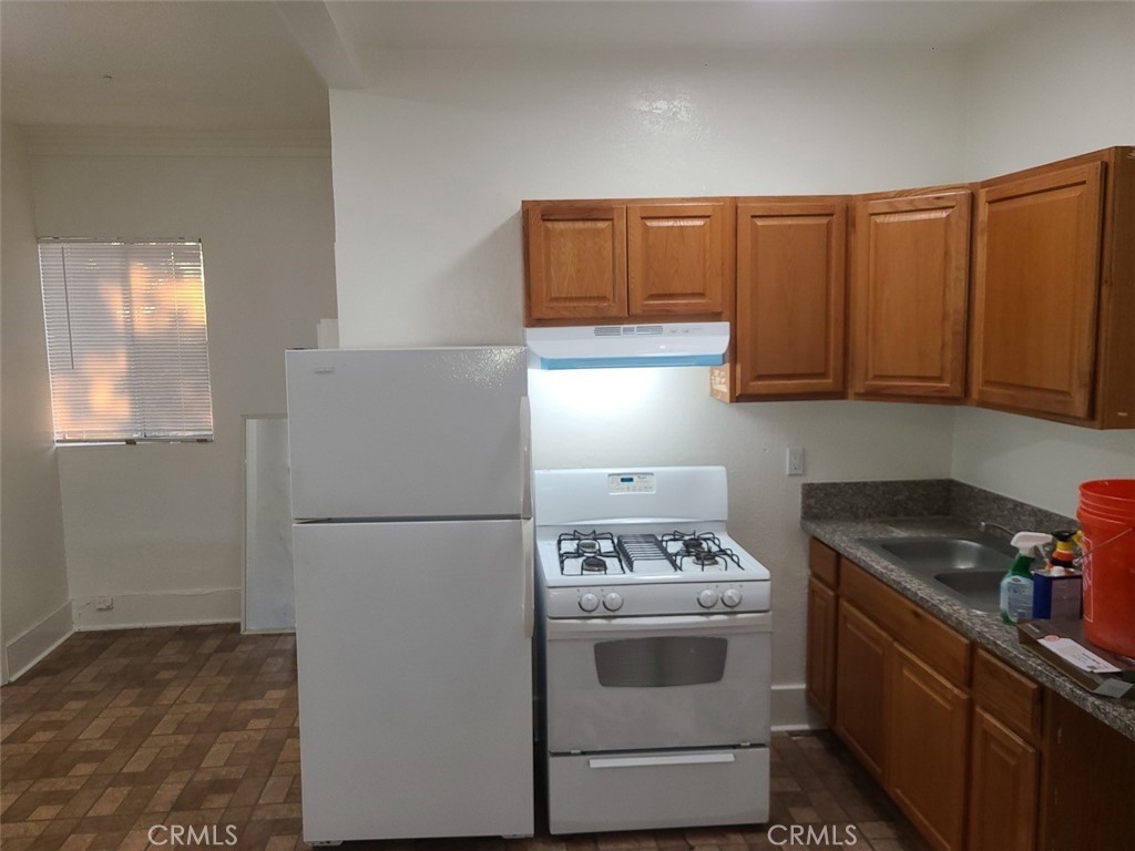127 North Burlington Avenue, Unit C Los Angeles, CA 90026 - Photo 6 of 8 a white refrigerator freezer sitting inside of a kitchen