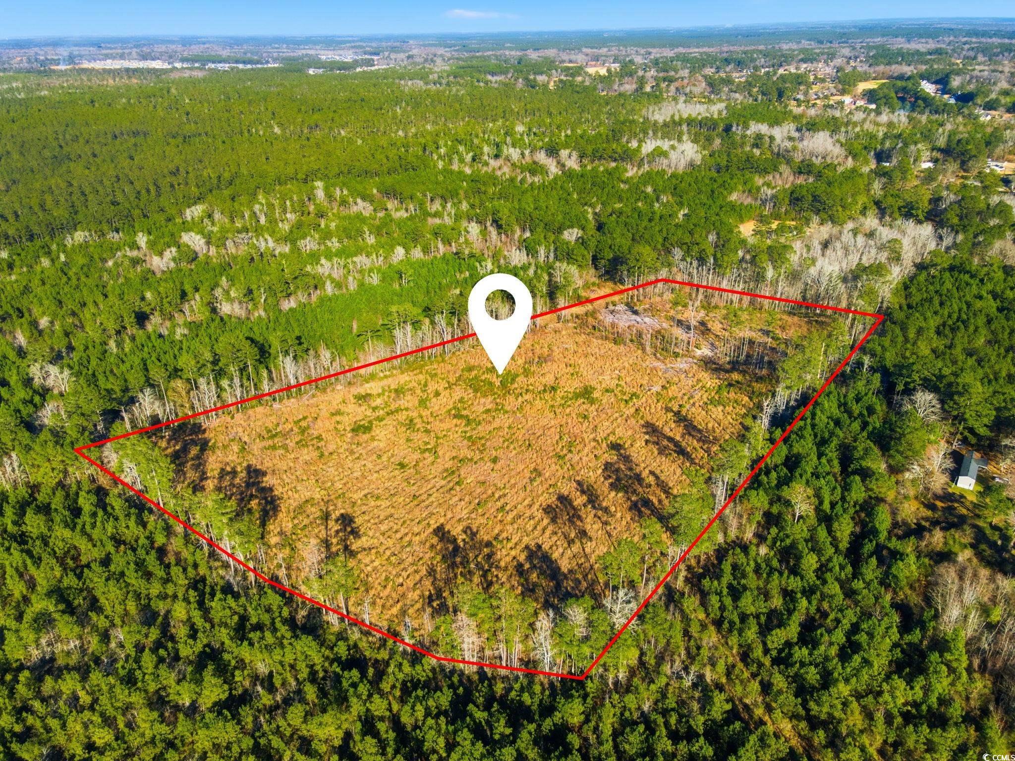 Aerial view of property's location featuring property boundaries highlighted and a heavily wooded area