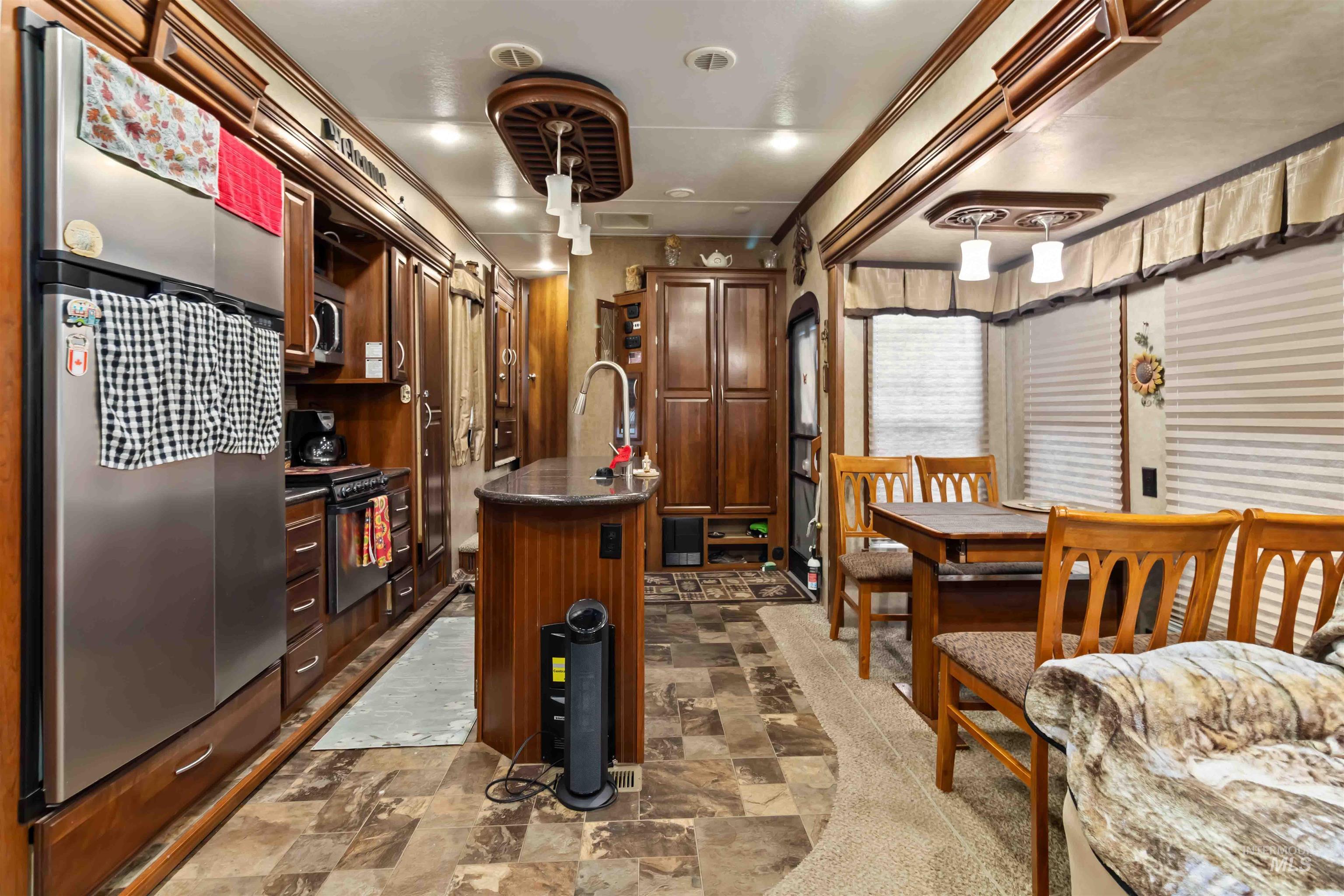 H05 North Sawyer Street Cascade, ID 83611 - Photo 13 of 40 Kitchen with freestanding refrigerator, stone finish floors, a kitchen island with sink, and dark brown cabinets