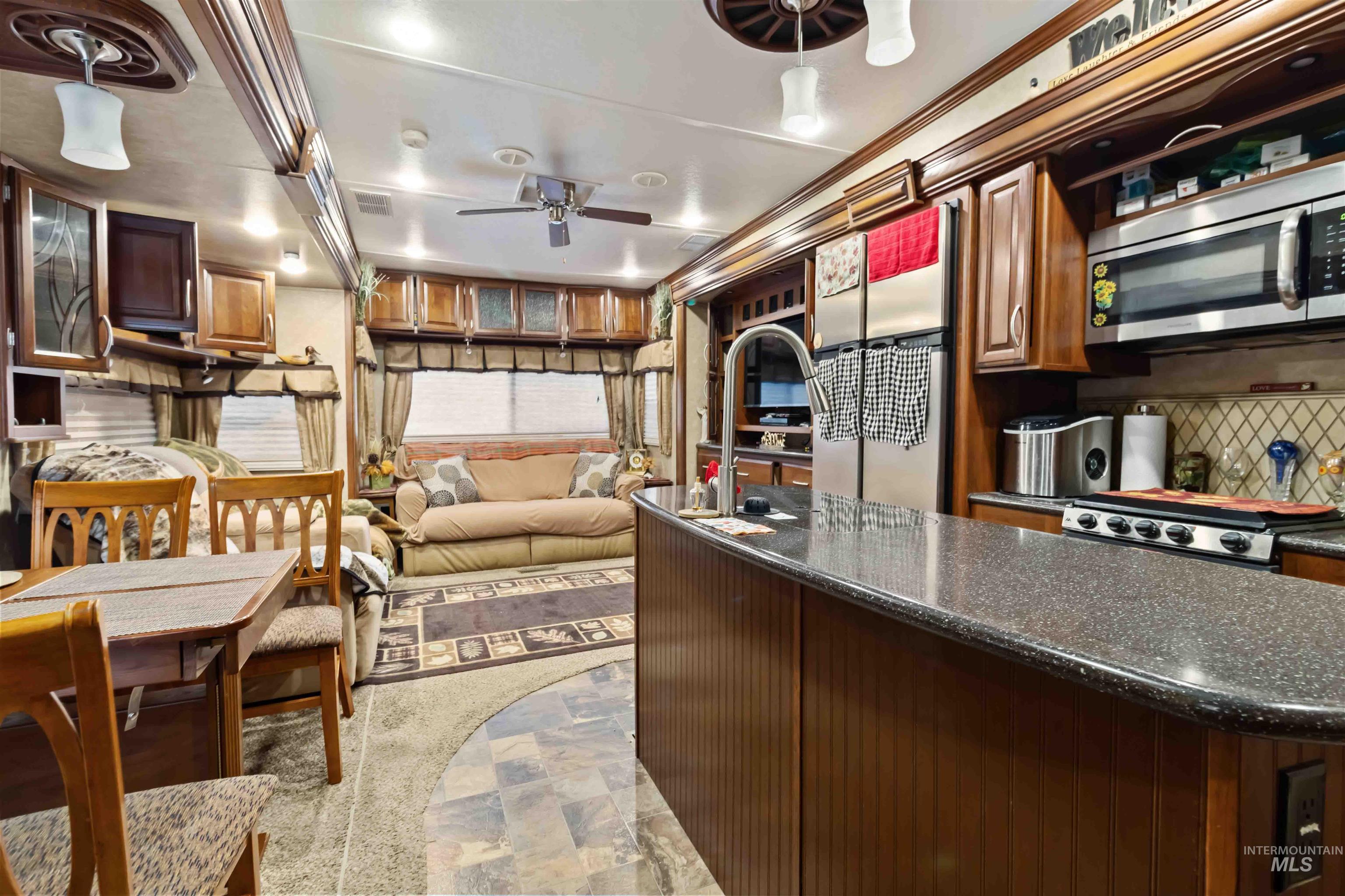 H05 North Sawyer Street Cascade, ID 83611 - Photo 8 of 40 Kitchen featuring stainless steel appliances, dark stone countertops, tasteful backsplash, stone finish floors, and ceiling fan