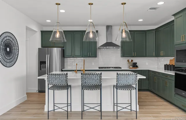 a kitchen with stainless steel appliances granite countertop a kitchen island a stove and a refrigerator