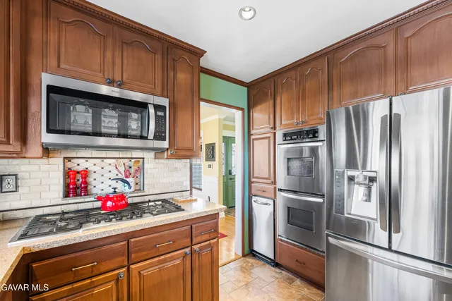 a kitchen with stainless steel appliances granite countertop a refrigerator and a sink