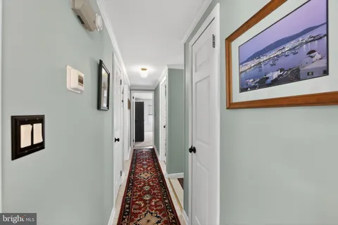 a view of a hallway with wooden floor and entryway