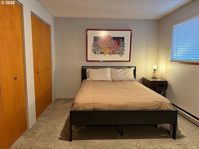 1005 Maple Street Myrtle Point, OR 97458 - Photo 14 of 32 a room with a bed and paintings on the wall