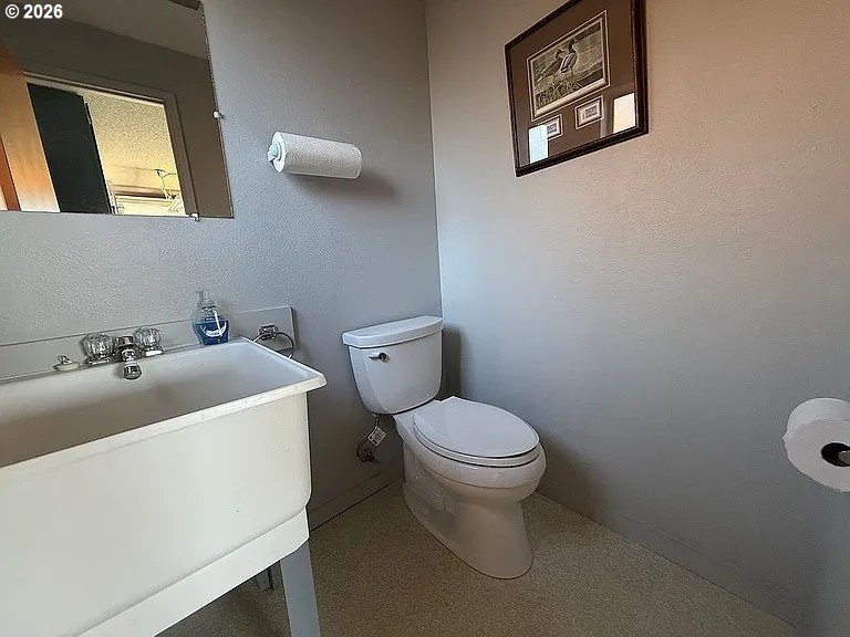 1005 Maple Street Myrtle Point, OR 97458 - Photo 26 of 32 a bathroom with a sink a toilet and mirror