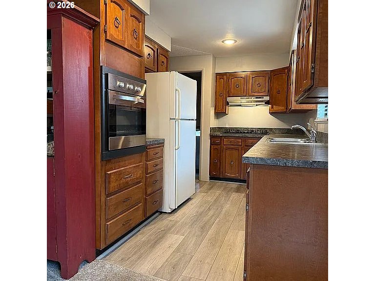 1005 Maple Street Myrtle Point, OR 97458 - Photo 9 of 32 a kitchen with granite countertop a refrigerator and a sink