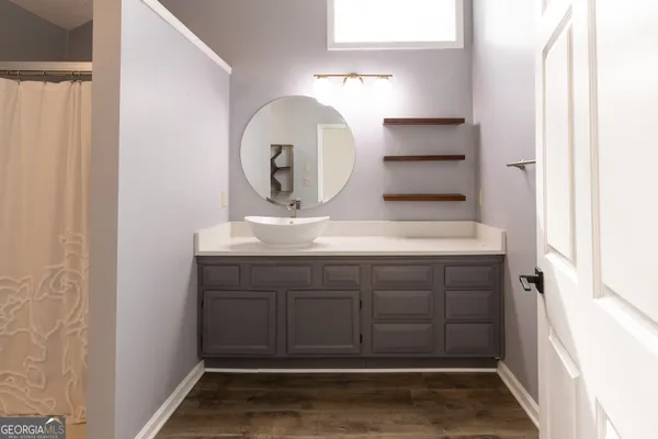 an empty room with wooden floor cabinet and windows