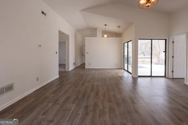 a view of an empty room with wooden floor