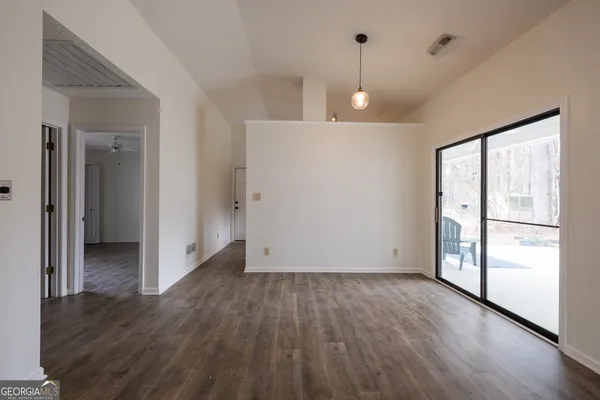 a view of a room with an empty space and wooden floor