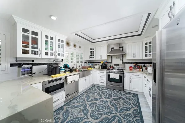 a kitchen with stainless steel appliances granite countertop a refrigerator and wooden cabinets