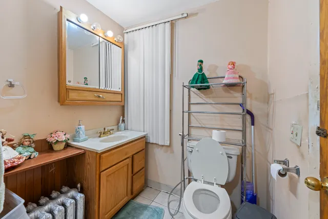 a bathroom with a sink vanity mirror and toilet