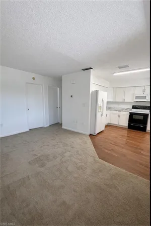 a view of a livingroom with furniture and a refrigerator
