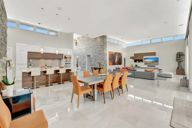 a dining room with stainless steel appliances kitchen island granite countertop a table and chairs