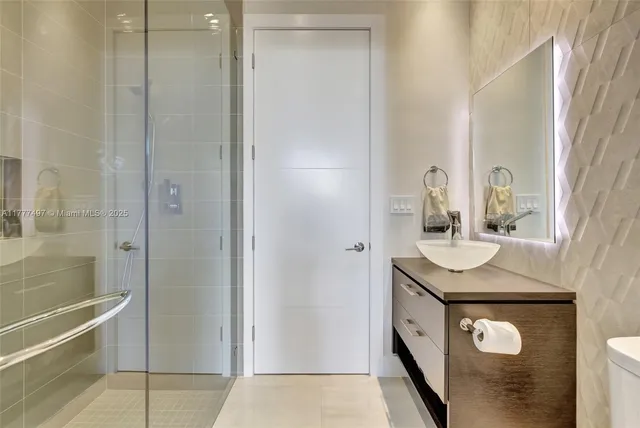 a bathroom with a toilet a sink a mirror and a shower