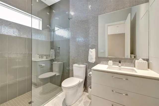a bathroom with a sink a toilet a shower and a mirror