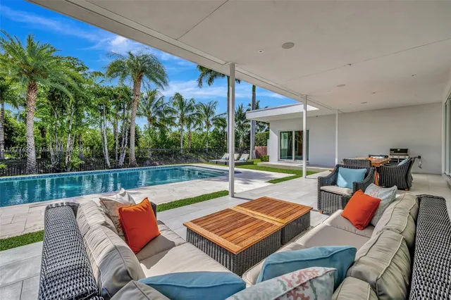 a view of a house with swimming pool and sitting area