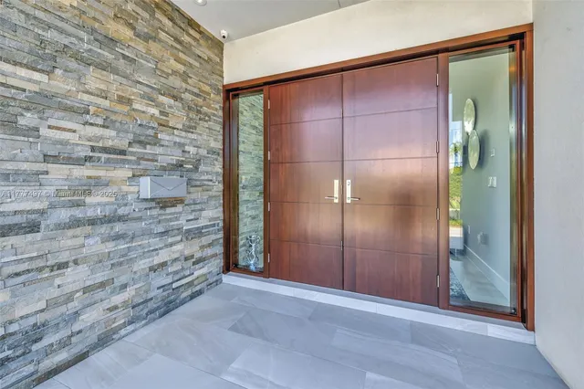a view of an empty room with brick wall and a mirror