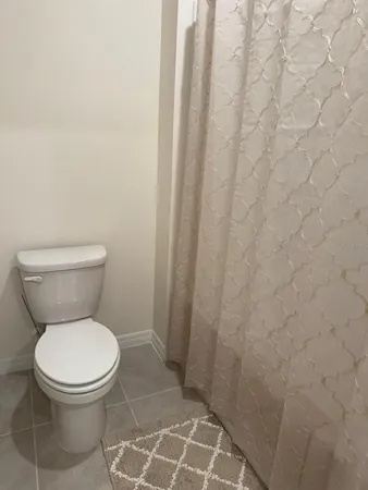 a white toilet sitting next to a shower curtain