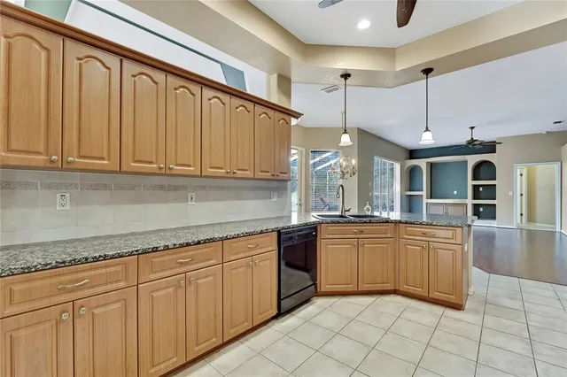 a kitchen with stainless steel appliances granite countertop a refrigerator a oven and a sink with granite countertops
