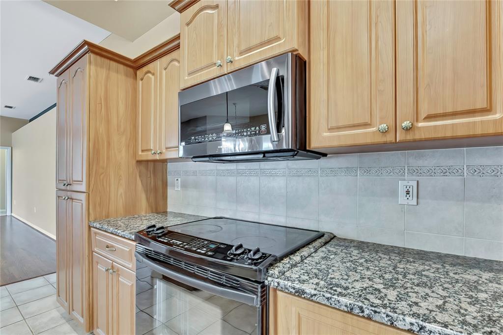 12403 Centennial Street Spring Hill, FL 34609 - Photo 17 of 62 a kitchen with stainless steel appliances granite countertop a stove and a microwave