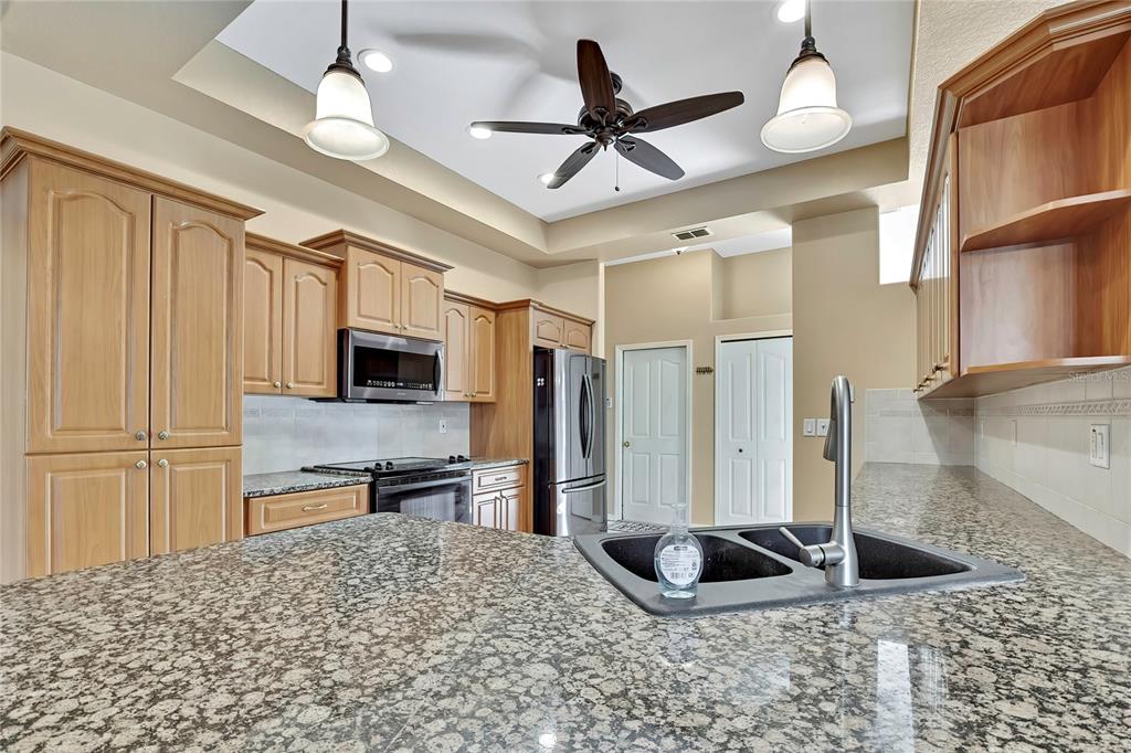 12403 Centennial Street Spring Hill, FL 34609 - Photo 19 of 62 a kitchen with stainless steel appliances granite countertop a refrigerator a oven and a sink with granite countertops