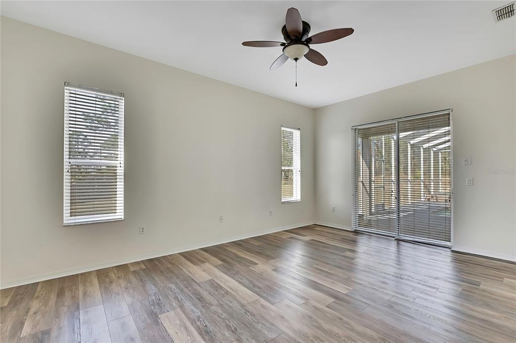 12403 Centennial Street Spring Hill, FL 34609 - Photo 25 of 62 a view of an empty room with wooden floor and a window