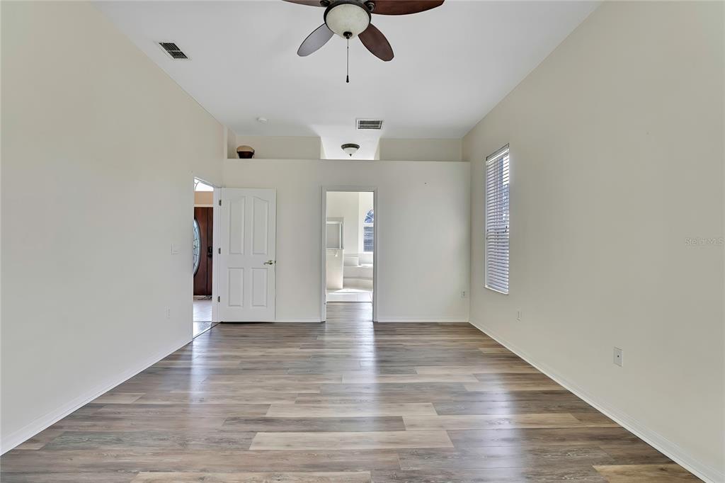 12403 Centennial Street Spring Hill, FL 34609 - Photo 27 of 62 a view of an empty room with a window and wooden floor