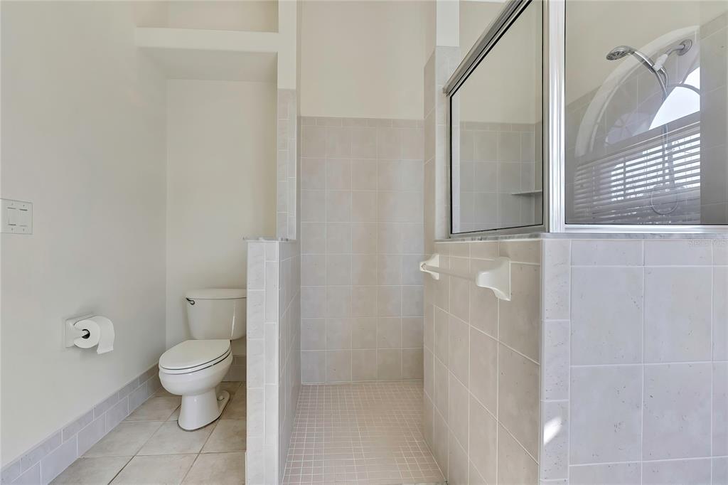 12403 Centennial Street Spring Hill, FL 34609 - Photo 33 of 62 a bathroom with a granite countertop sink a toilet and a mirror