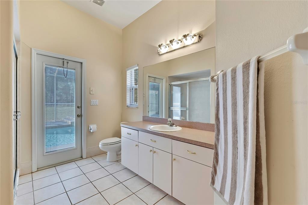 12403 Centennial Street Spring Hill, FL 34609 - Photo 44 of 62 a spacious bathroom with a granite countertop sink toilet a mirror a vanity and shower