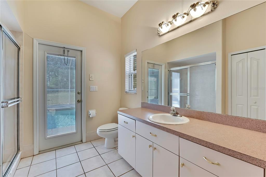 12403 Centennial Street Spring Hill, FL 34609 - Photo 45 of 62 a bathroom with a granite countertop sink a toilet a mirror and shower