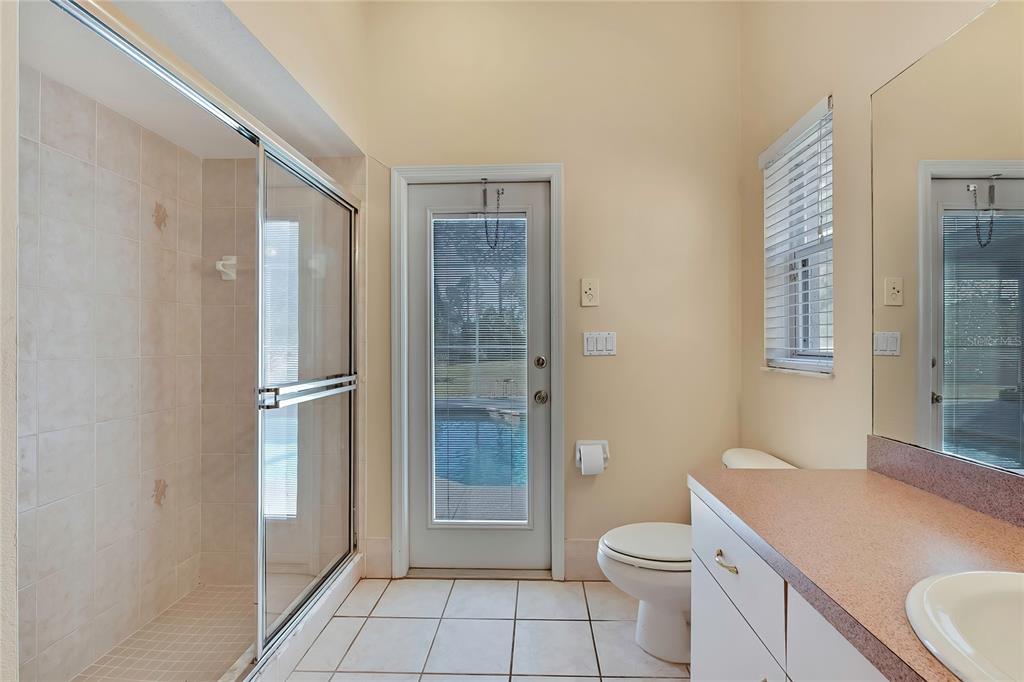 12403 Centennial Street Spring Hill, FL 34609 - Photo 46 of 62 a bathroom with a granite countertop toilet a sink and a shower