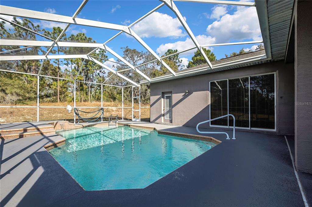 12403 Centennial Street Spring Hill, FL 34609 - Photo 51 of 62 a view of a swimming pool with outdoor seating