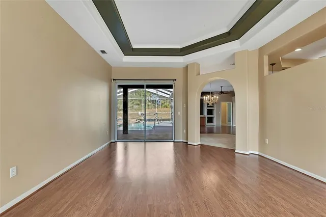 a view of a hallway with wooden floor and a window