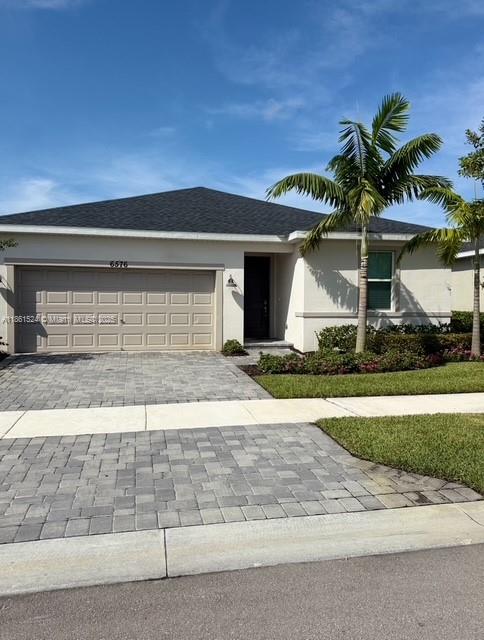 6576 Cloverdale Avenue Port St. Lucie, FL 34987 - Photo 1 of 32 a front view of a house with a yard and garage