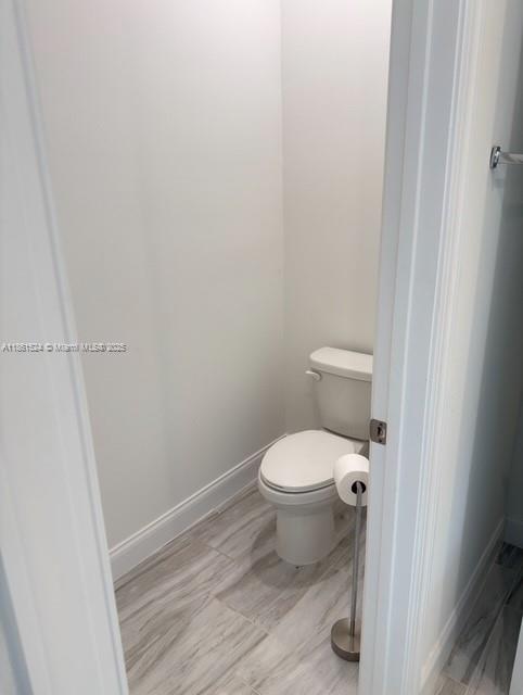 6576 Cloverdale Avenue Port St. Lucie, FL 34987 - Photo 9 of 32 a bathroom with a toilet and a wooden floor