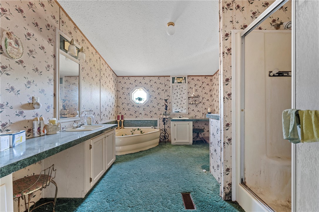 3725 Bluhm Road West, TX 76691 - Photo 7 of 26 a large bathroom with a granite countertop sink a toilet and shower