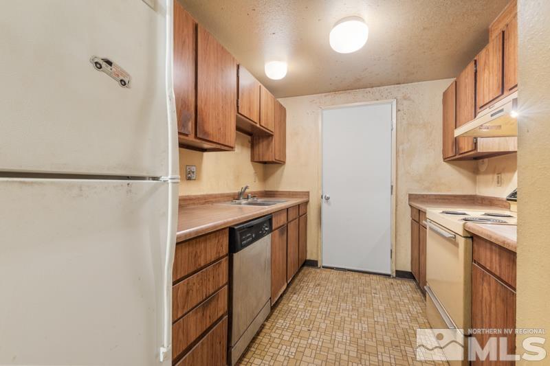 1376 Butler Street Reno, NV 89512 - Photo 4 of 12 a kitchen with stainless steel appliances granite countertop a refrigerator and a stove