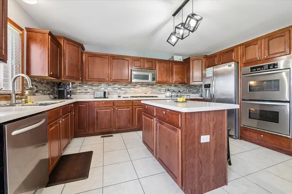 a kitchen with stainless steel appliances granite countertop a sink stove and cabinets