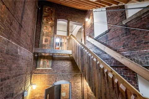 a view of balcony with wooden floor and brick walls