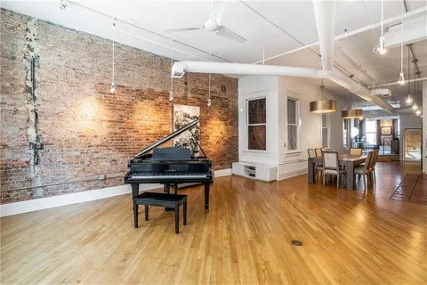 a view of entryway with wooden floor and small seating area