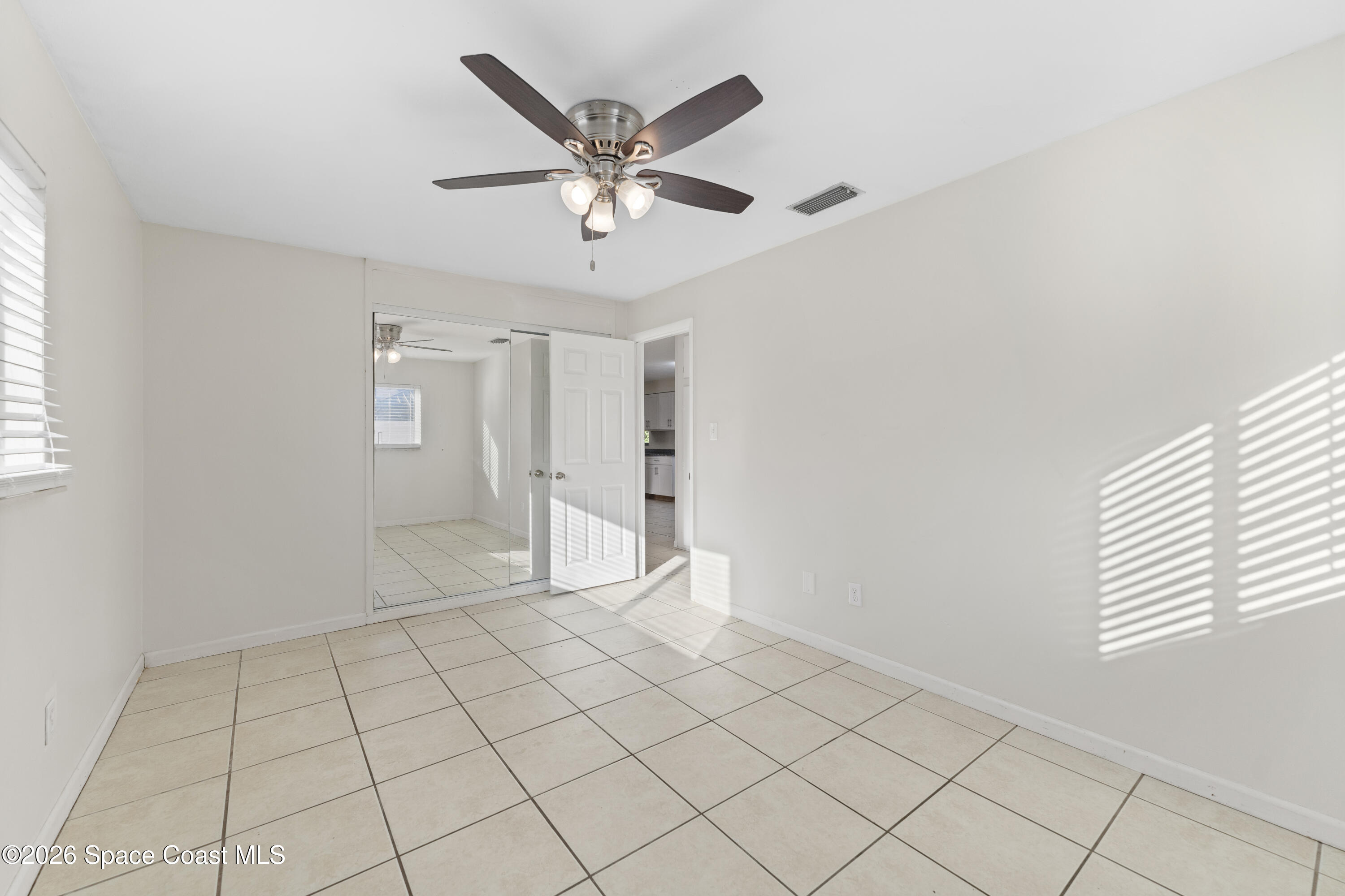 420 South Tropical Trail Merritt Island, FL 32952 - Photo 13 of 20 an empty room with windows and fan