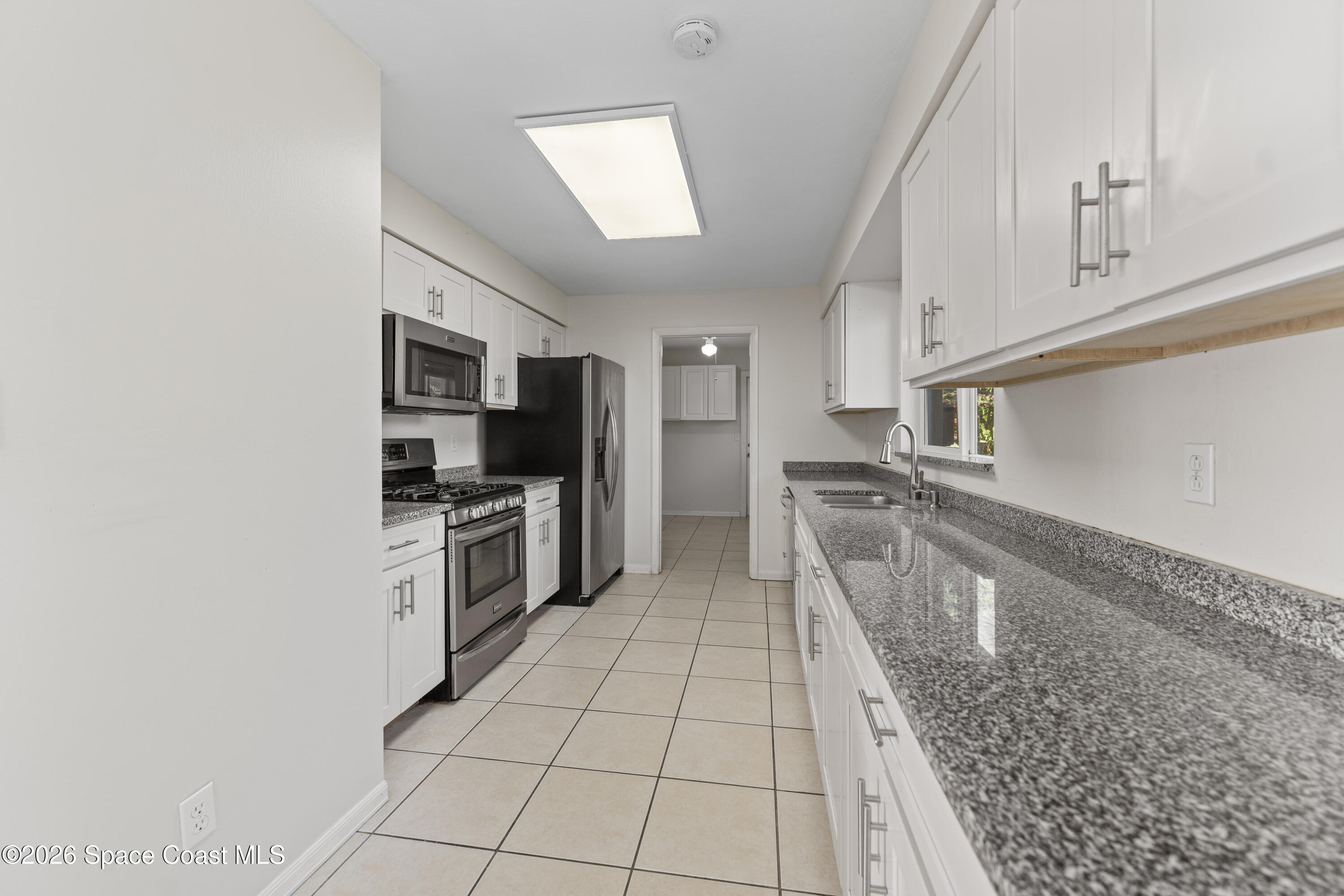 420 South Tropical Trail Merritt Island, FL 32952 - Photo 5 of 20 a large white kitchen with sink and stainless steel appliances