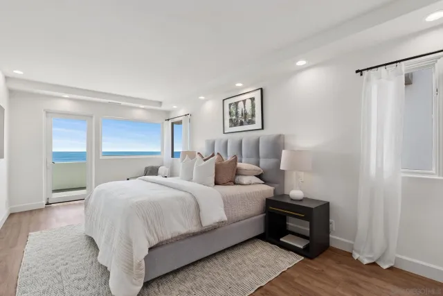 a spacious bedroom with a bed a couch and a view of kitchen