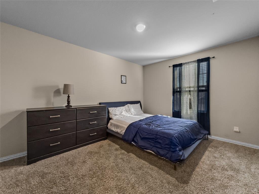 2745 Acadia Drive Corinth, TX 76210 - Photo 24 of 27 a bedroom with a bed and a window