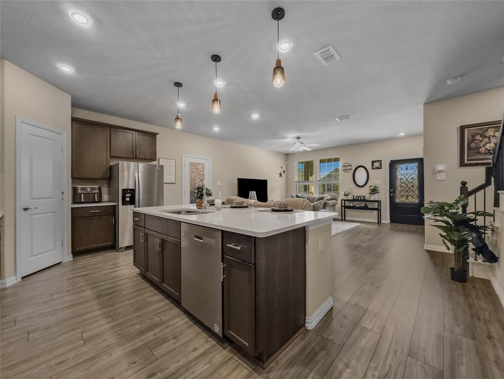 2745 Acadia Drive Corinth, TX 76210 - Photo 7 of 27 a large kitchen with stainless steel appliances granite countertop a large center island and a sink