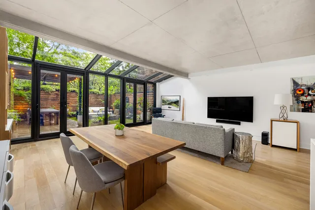 a living room with furniture a flat screen tv and a floor to ceiling window
